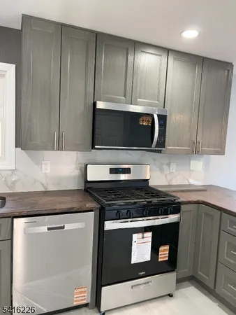 a kitchen with granite countertop cabinets stove and microwave