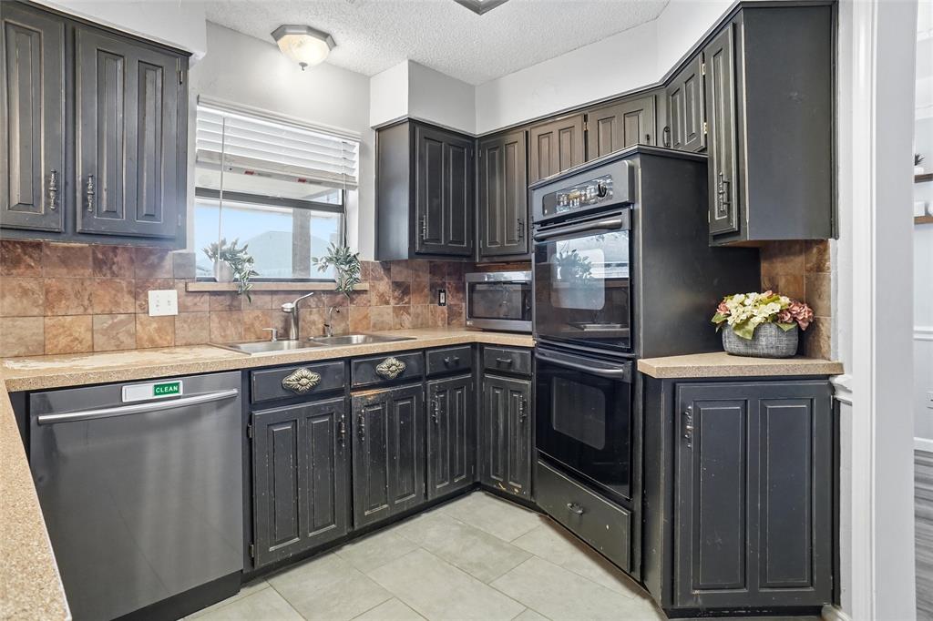 2613 Stone Hollow Drive Bedford, TX 76021 - Photo 9 of 33 a kitchen with granite countertop a sink stove and refrigerator