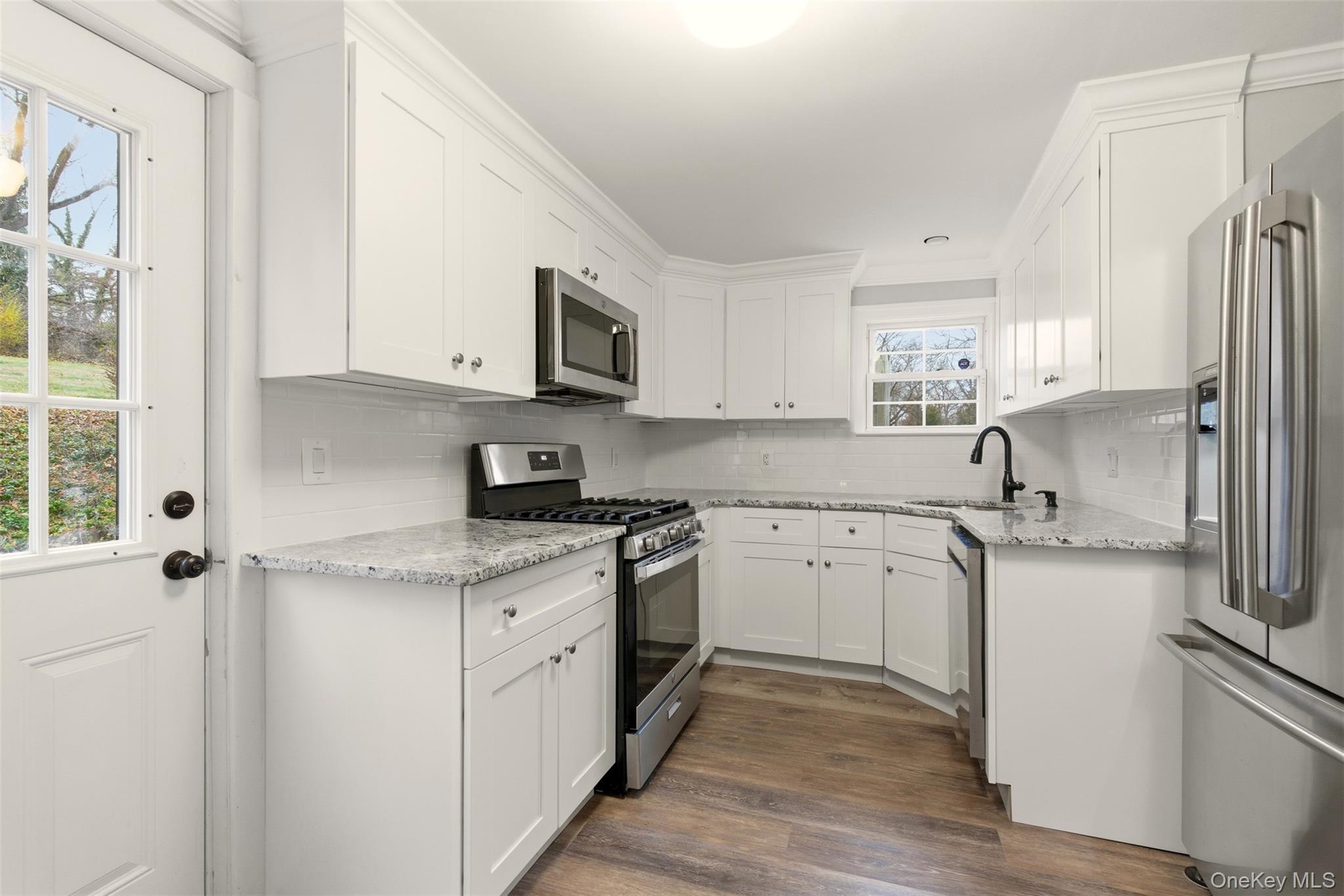 327 West Neck Road Lloyd Harbor, NY 11743 - Photo 6 of 24 a kitchen with granite countertop white cabinets and white appliances