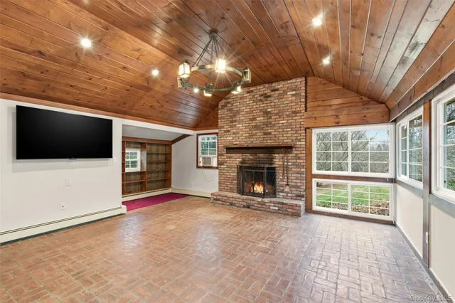 a view of an empty room with a fireplace and a chandelier