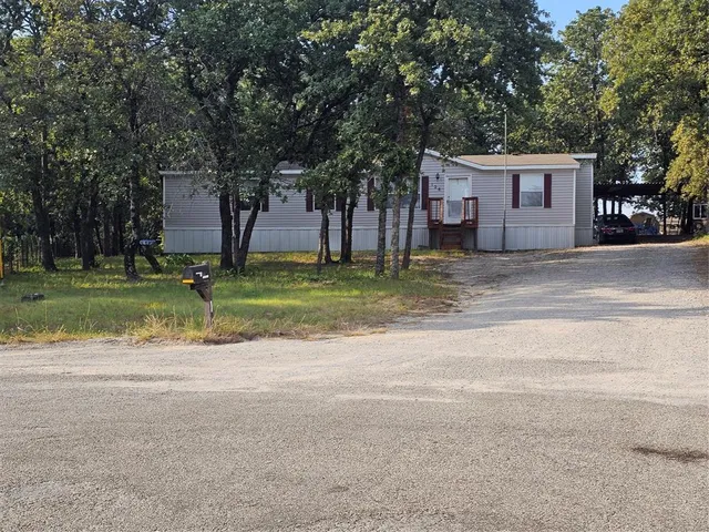 a backyard of a house with a large tree