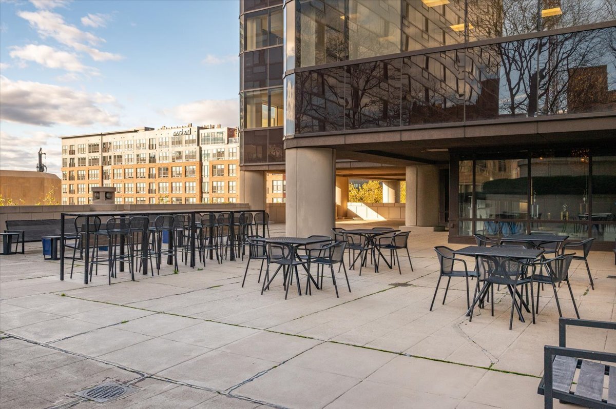 127 Greyrock Place, Unit 810 Stamford, CT 06901 - Photo 22 of 34 a view of a patio with dining table and chairs with a large tree