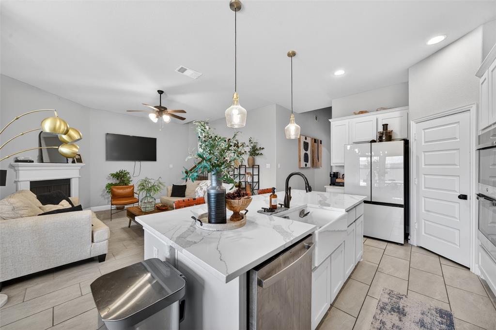 3245 Ribisl Lane Royse City, TX 75189 - Photo 38 of 39 Kitchen featuring open floor plan, a ceiling fan, stainless steel appliances, a center island with sink, and white cabinetry