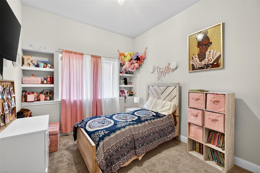 3245 Ribisl Lane Royse City, TX 75189 - Photo 22 of 39 a bedroom with a bed and a book shelf
