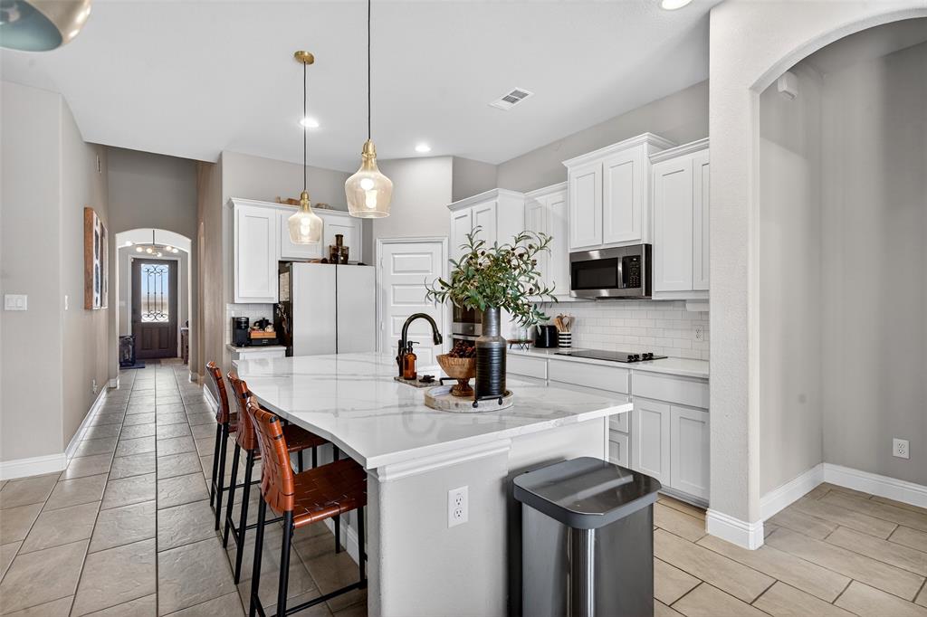 3245 Ribisl Lane Royse City, TX 75189 - Photo 10 of 39 a kitchen with stainless steel appliances a sink a stove a refrigerator a center island and cabinets