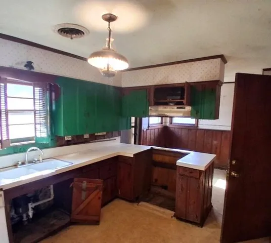 a kitchen with kitchen island granite countertop a sink stainless steel appliances and cabinets