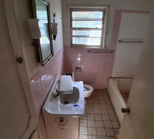 a bathroom with a sink toilet and a mirror
