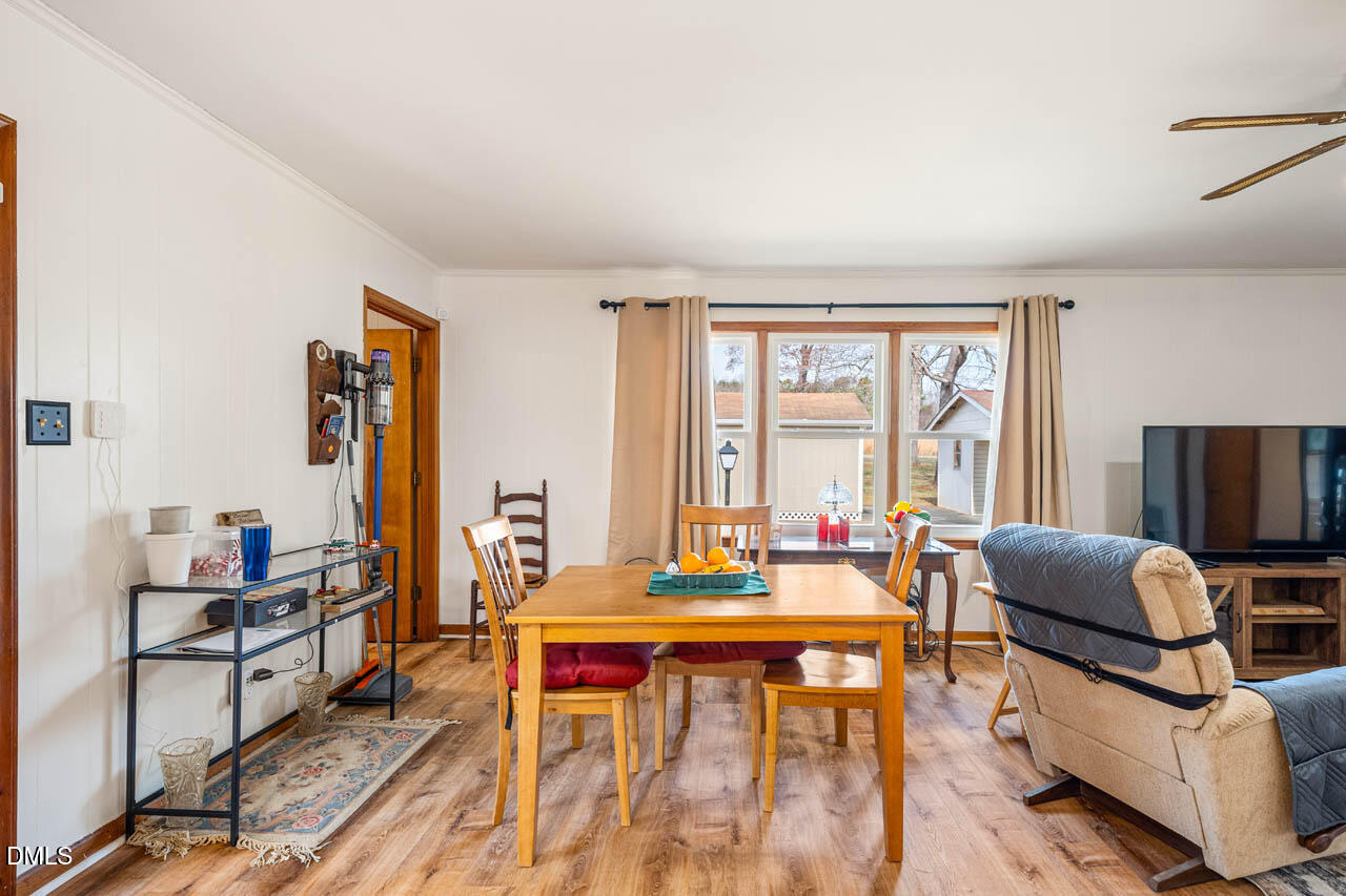 200 Sawmill Road Cedar Grove, NC 27231 - Photo 5 of 72 a living room with furniture a flat screen tv and a floor to ceiling window
