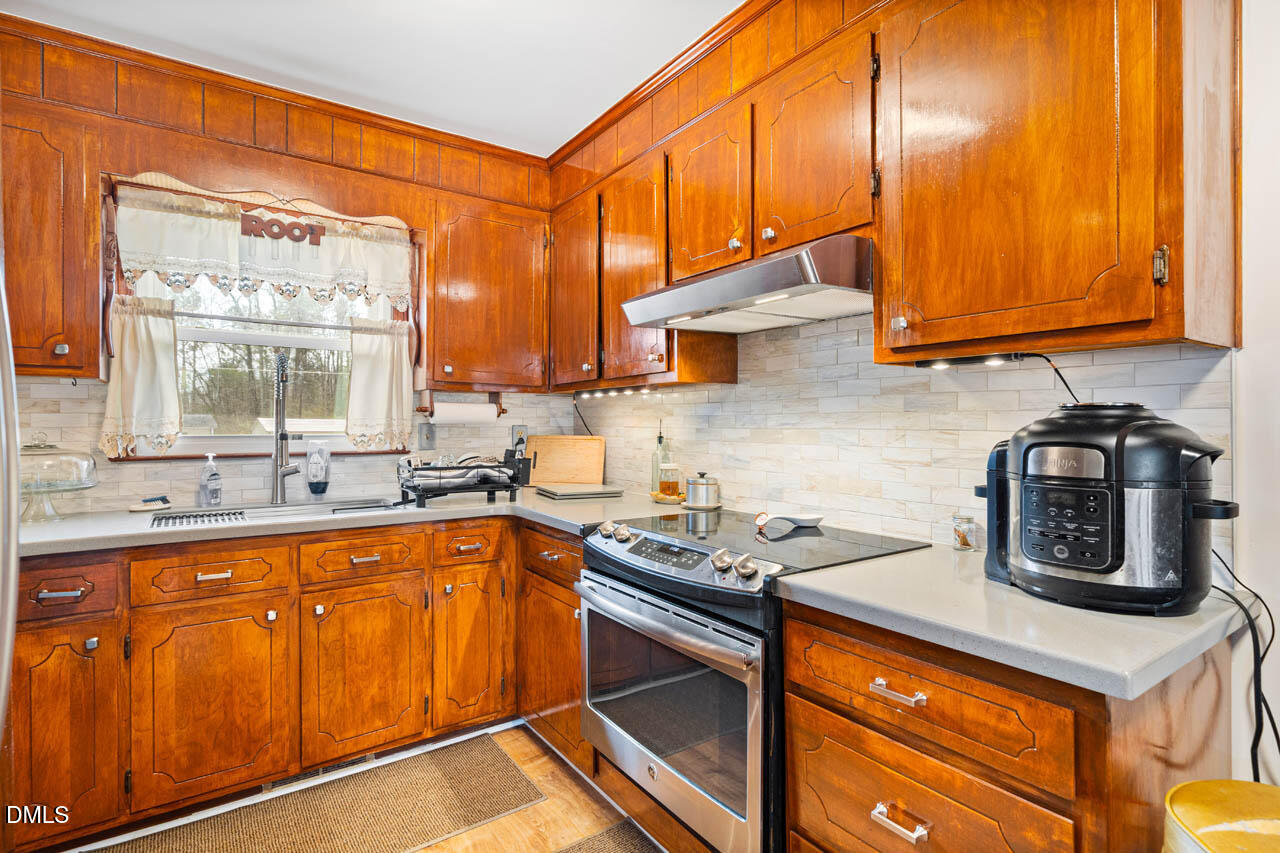 200 Sawmill Road Cedar Grove, NC 27231 - Photo 9 of 72 a kitchen with stainless steel appliances granite countertop a sink stove and cabinets