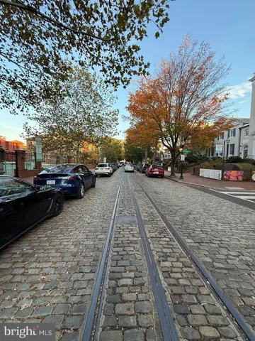 a view of a yard with cars parked on the roadside