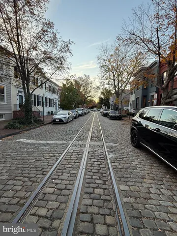 a view of a yard with cars parked on the roadside