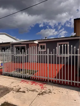a view of a house with a wooden fence