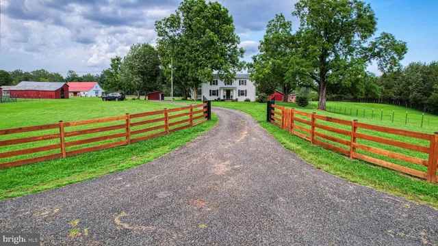 a view of a white house with a yard and plants