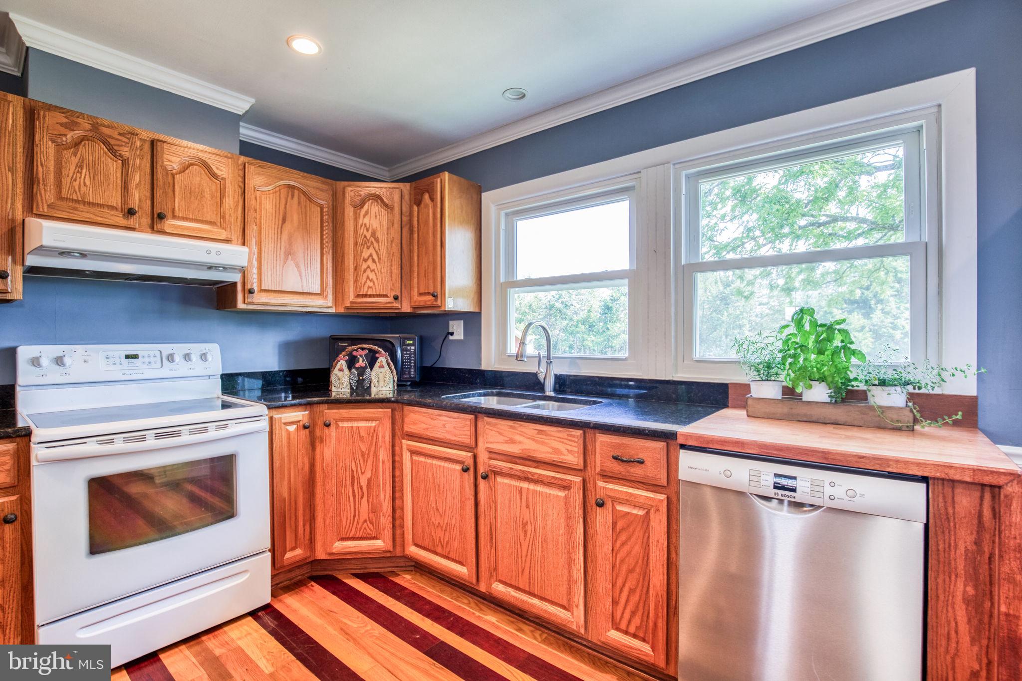 1815 Country Road Beaverdam, VA 23015 - Photo 19 of 92 a kitchen with stainless steel appliances granite countertop a sink a stove a washer dryer and wooden cabinets