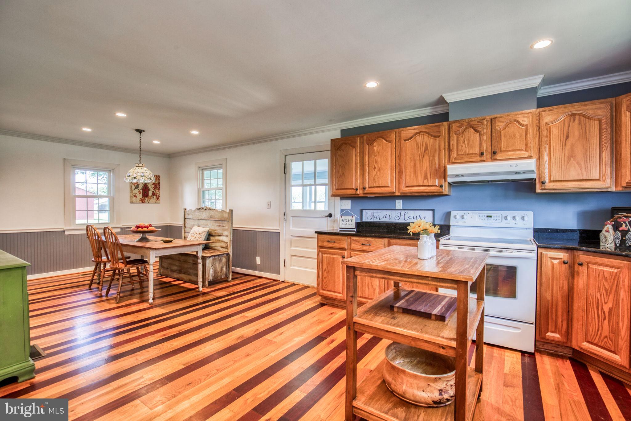 1815 Country Road Beaverdam, VA 23015 - Photo 21 of 92 a kitchen with stainless steel appliances granite countertop a stove top oven a sink dishwasher a dining table and chairs with wooden floor