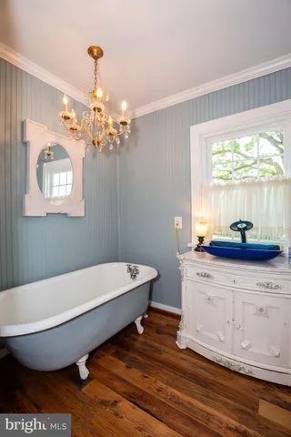 a bedroom with a bed and a dresser next to a window