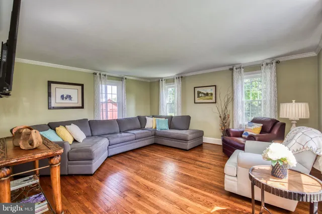 a view of a dining room with furniture a chandelier and wooden floor