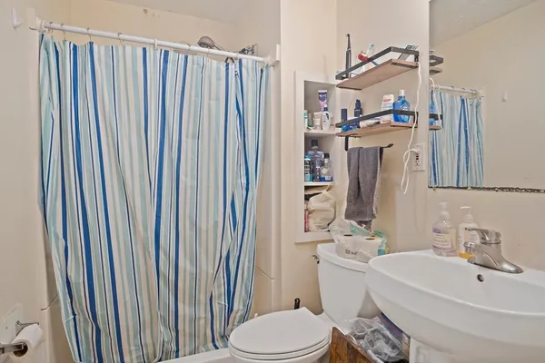 a bathroom with a sink a toilet and shower