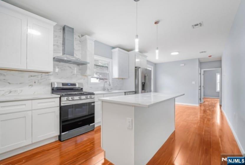 125 Birch Street, Unit 2 Bloomfield, NJ 07003 - Photo 5 of 11 a kitchen with stainless steel appliances kitchen island granite countertop a sink a stove a refrigerator and white cabinets with wooden floor