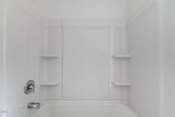 a view of empty room with a fireplace and wooden floor
