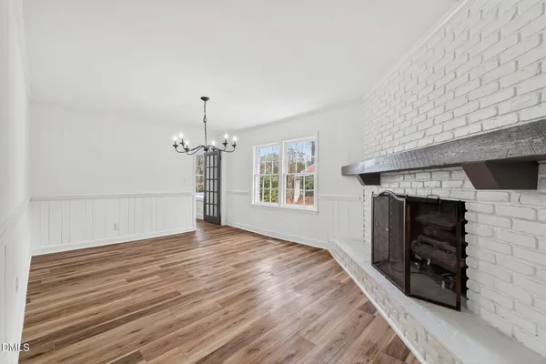 a view of empty room with fireplace and wooden floor