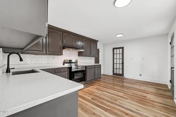 a kitchen with stainless steel appliances a sink stove and cabinets