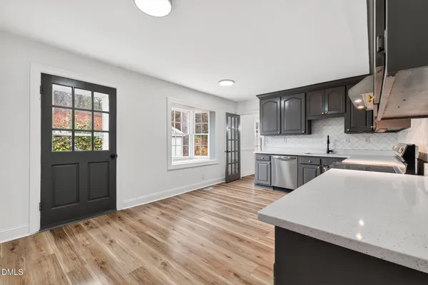 a kitchen with white cabinets and sink