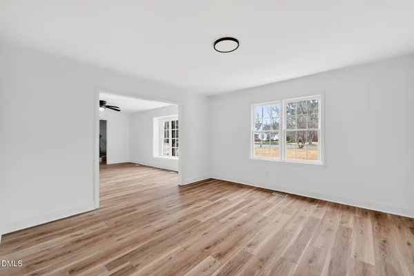 a view of a livingroom with a ceiling fan and wooden floor