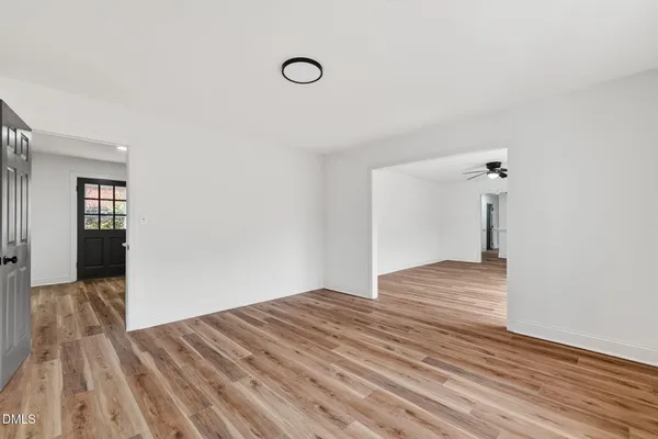 a view of empty room with wooden floor and ceiling fan