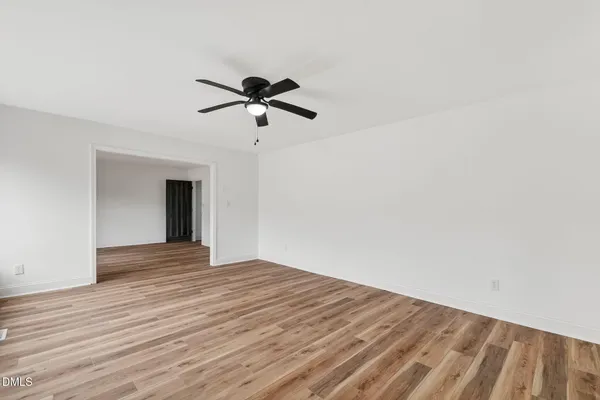 a view of an empty room with a window and a ceiling fan