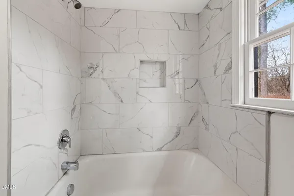 a view of empty room with wooden floor and ceiling fan