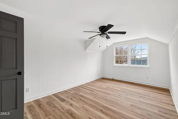 a view of a livingroom with wooden floor and a ceiling fan