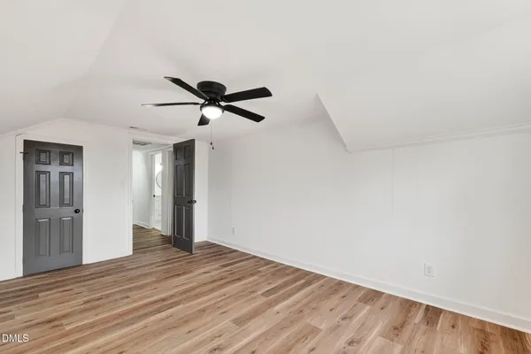 a view of a hallway with white walls and a window
