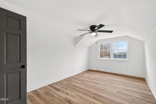 an empty room with windows and fireplace