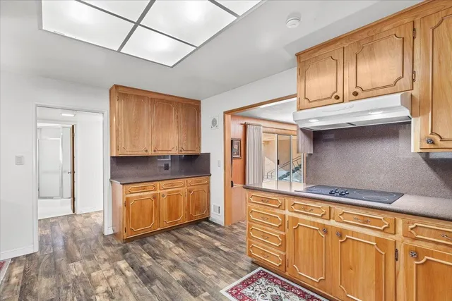 a kitchen with granite countertop cabinets stainless steel appliances and a counter space