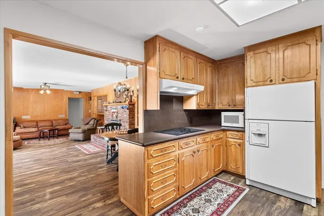 a kitchen with a refrigerator a stove and wooden cabinets