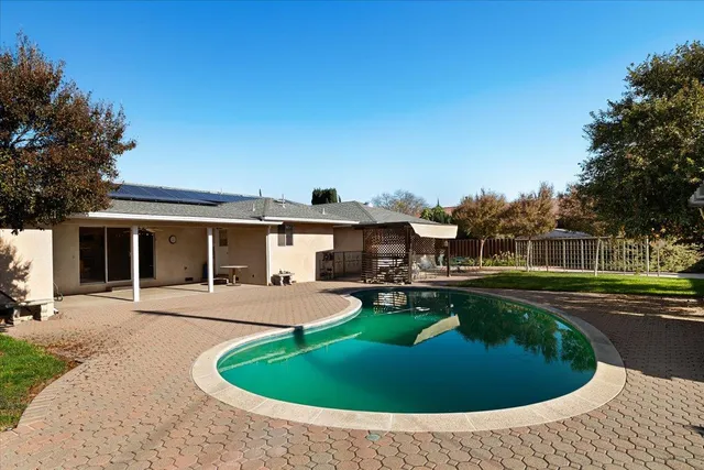 a view of a house with swimming pool and a yard