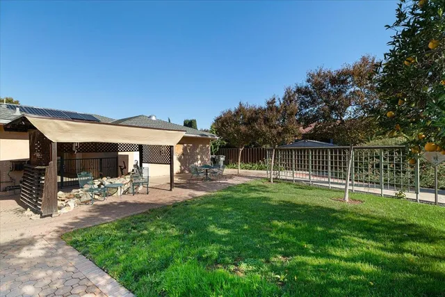 a view of a house with backyard and sitting area