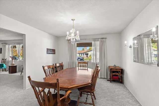 a view of a dining room with furniture and chandelier