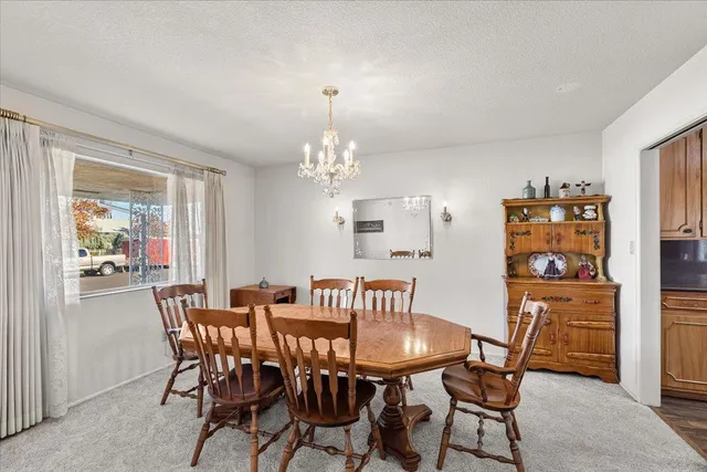 a view of a dining room with furniture and chandelier