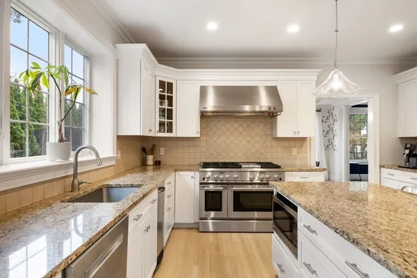 a kitchen with a stove a sink and a granite counter tops