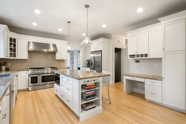 a large kitchen with stainless steel appliances granite countertop a stove and a sink