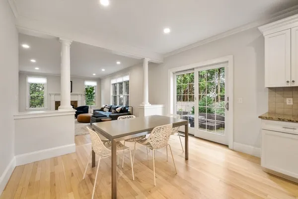 a view of a dining room and livingroom with furniture a rug a fireplace and windows