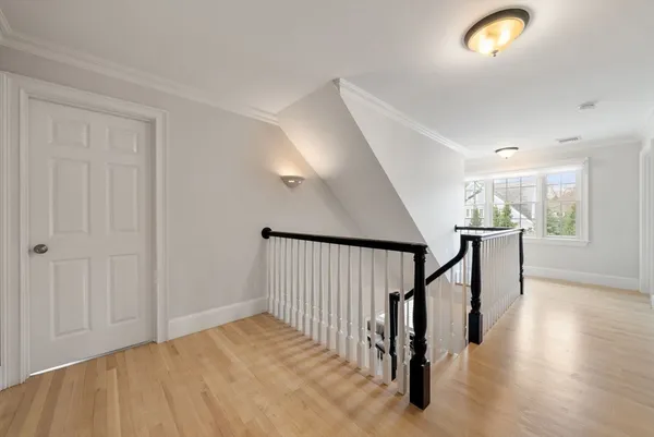 a view of a hallway with wooden floor and staircase