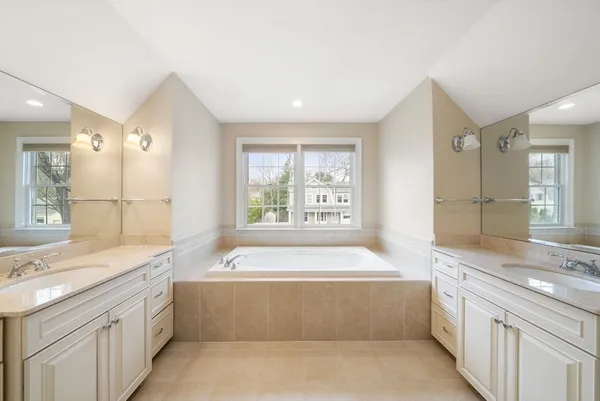 a spacious bathroom with a granite countertop tub sink and mirror