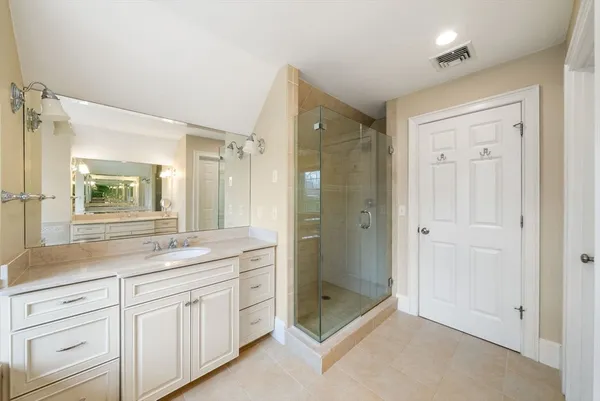 a spacious bathroom with a shower sink and mirror