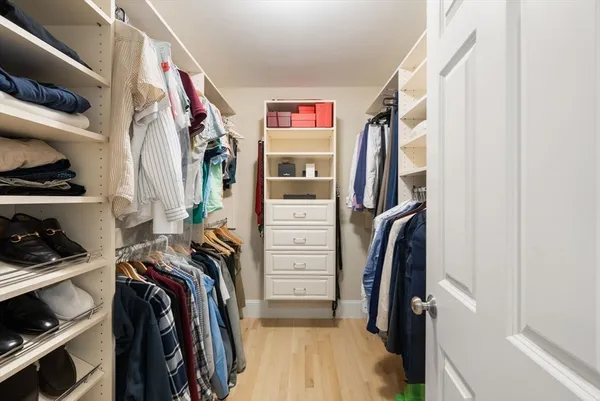 a view of walk in closet with clothes and shoes