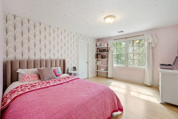 a bedroom with a large bed and a window