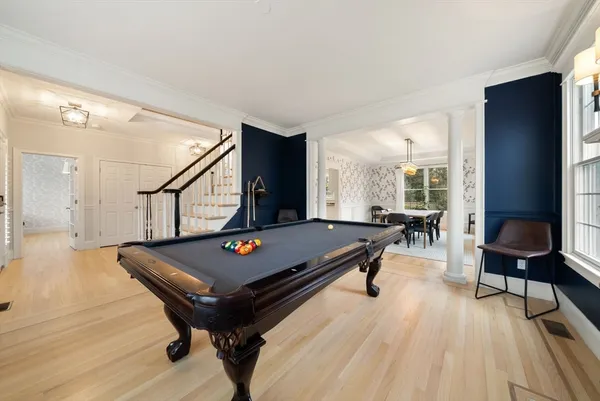 a living room with furniture pool table and a flat screen tv