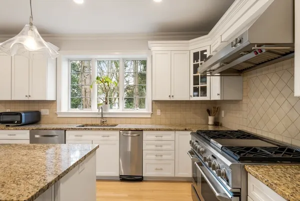 a kitchen with stainless steel appliances granite countertop a sink stove and cabinets